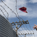 man's hand throwing his passport folded as a paper airplane over